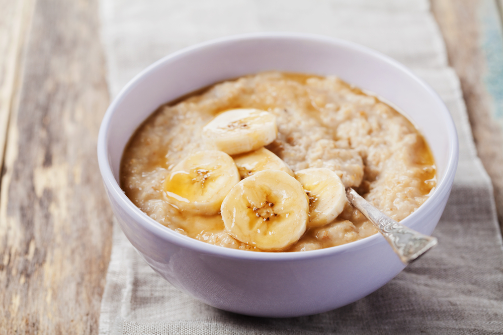 tigela branca com mingau de aveia e rodelas de banana